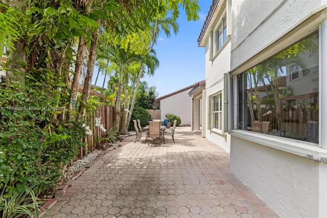 a view of a patio with table and chairs next to a yard