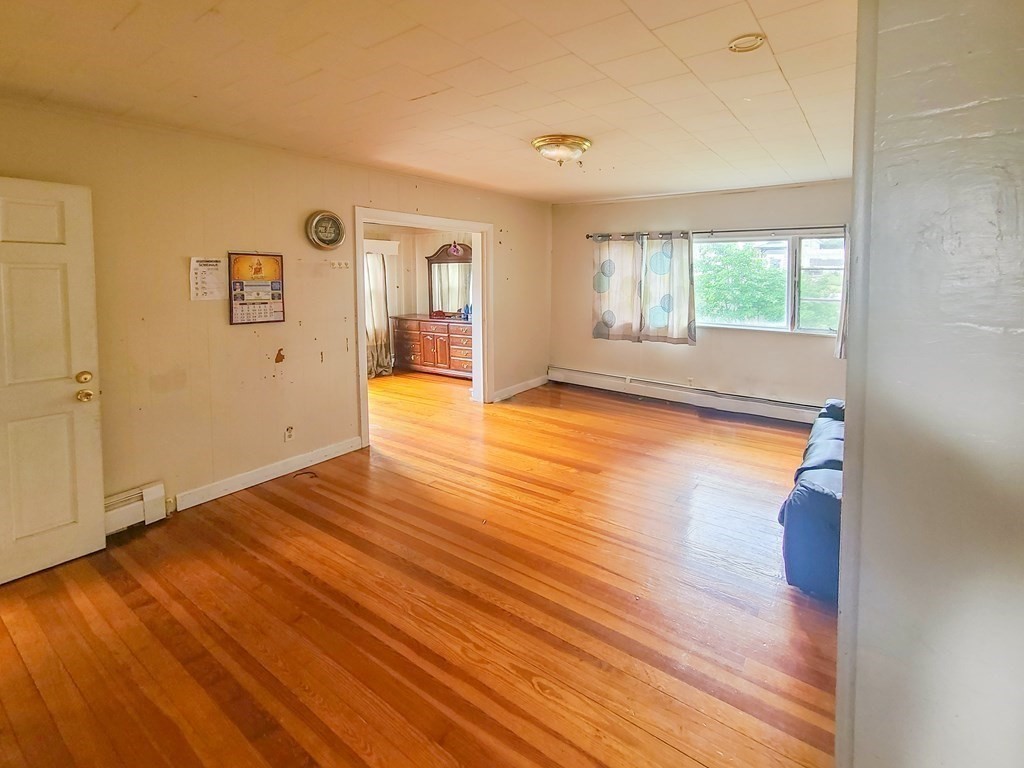 153 Field Street Fall River, MA 02721 - Photo 4 of 9 a view of an empty room with wooden floor and a window
