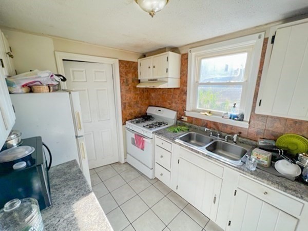 153 Field Street Fall River, MA 02721 - Photo 9 of 9 a kitchen with a sink a stove a refrigerator and cabinets