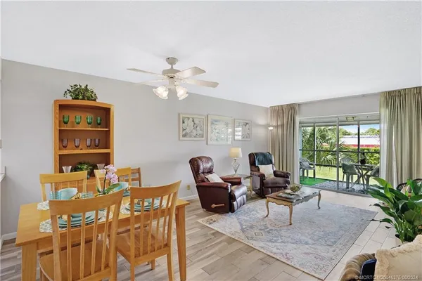 a living room with furniture a flat screen tv and a large window