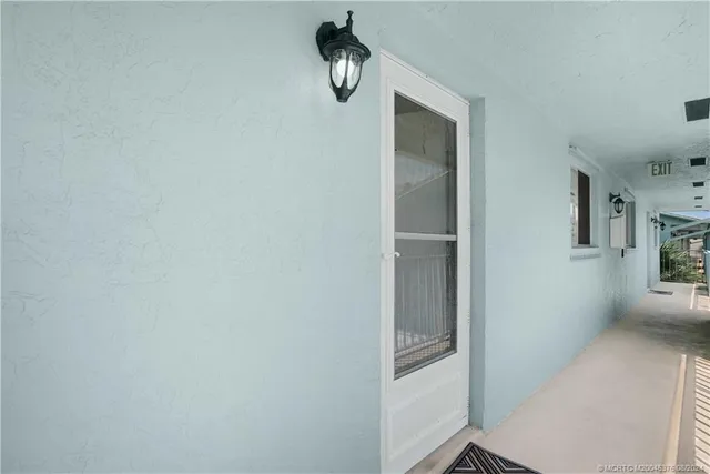 a kitchen with a refrigerator a sink cabinets and wooden floor