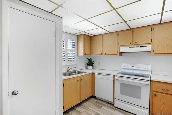 a kitchen with a sink cabinets and a window