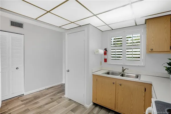 a view of a hallway with wooden floor and a livingroom with furniture