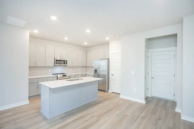 a kitchen with stainless steel appliances a sink stove and refrigerator