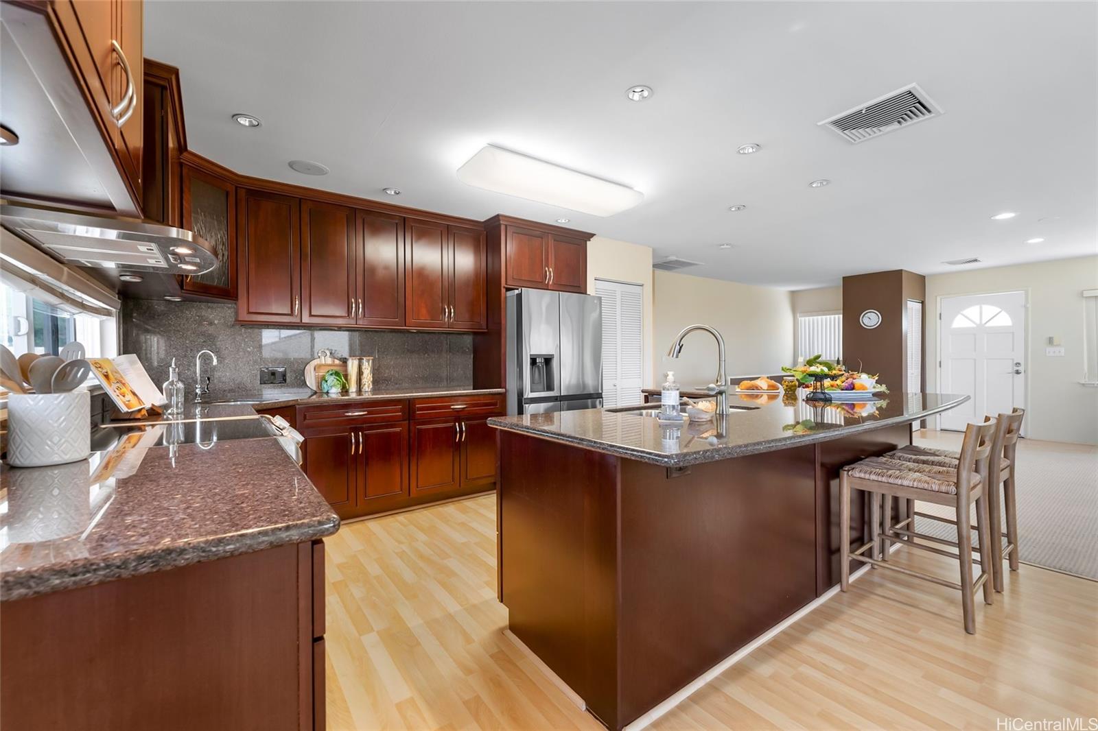 4562 Malia Street Honolulu, HI 96821 - Photo 3 of 25 a kitchen with stainless steel appliances granite countertop a sink stove and wooden cabinets
