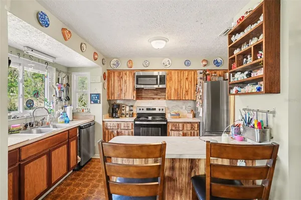 a kitchen with a stove a refrigerator and a dining table