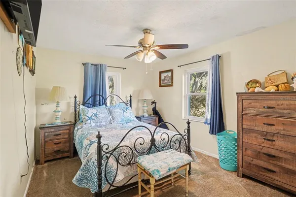 a bedroom with a bed and a flat tv screen on the dresser