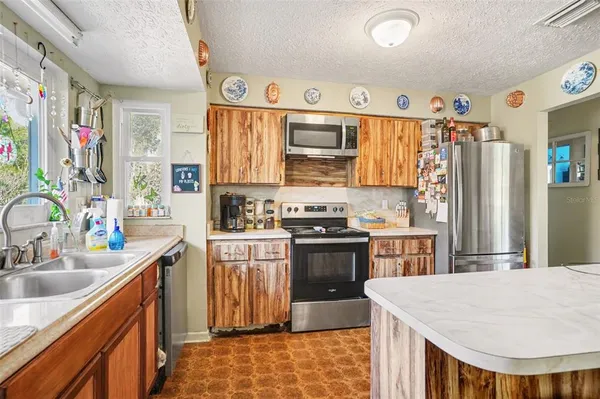 a kitchen with granite countertop a sink stove and refrigerator