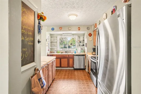a kitchen with stainless steel appliances granite countertop a refrigerator and a sink
