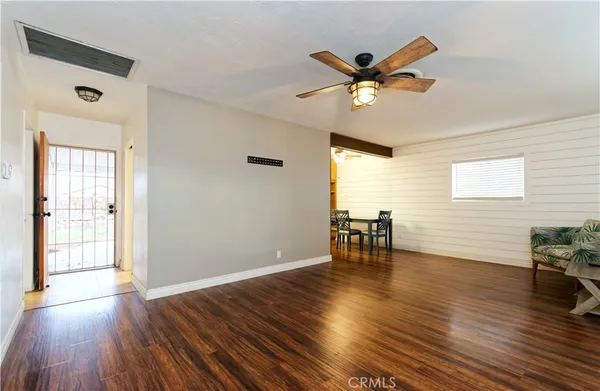 a view of a livingroom with furniture a ceiling fan and wooden floor