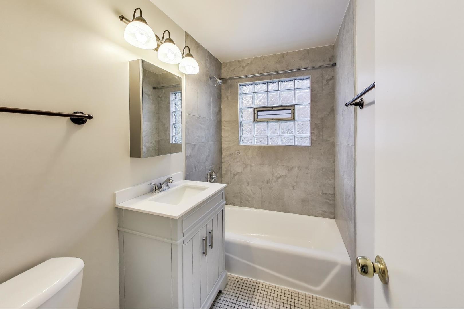 333 Short Street, Unit 2 Lemont, IL 60439 - Photo 7 of 11 a bathroom with a sink a toilet and shower