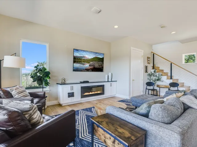 a living room with furniture a flat screen tv and a fireplace