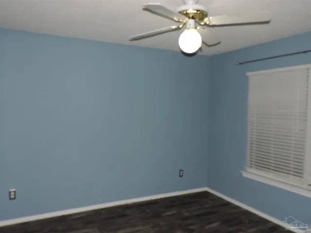 an empty room with wooden floor door and closet