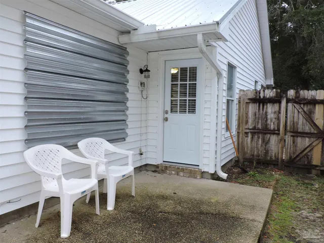 a view of backyard with wooden fence and large trees