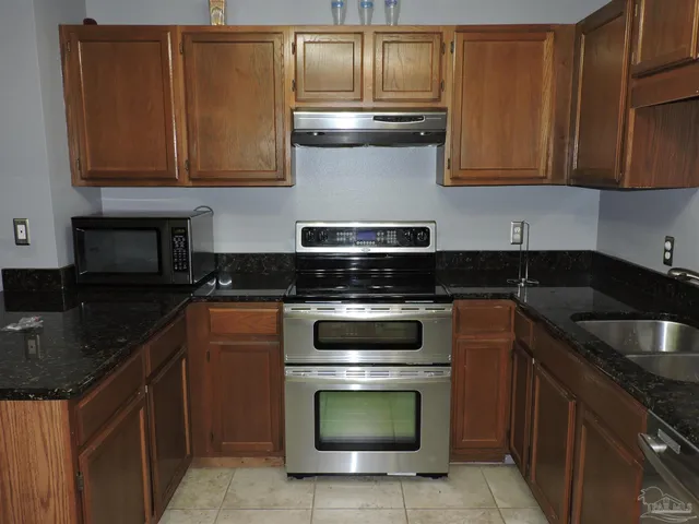 a metallic refrigerator freezer sitting in a kitchen