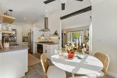 a dining room with furniture and a kitchen view