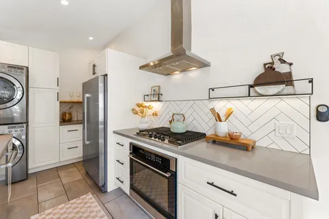 a kitchen with stainless steel appliances granite countertop a sink stove and refrigerator