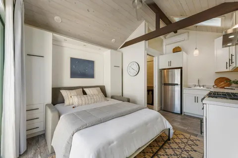 a bedroom with a bed and a refrigerator