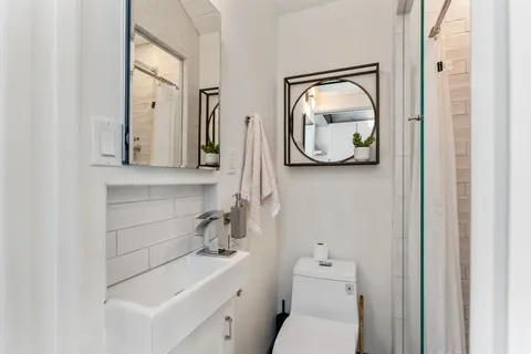 a bathroom with a toilet sink and mirror