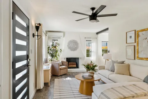a living room with furniture a fireplace and a chandelier