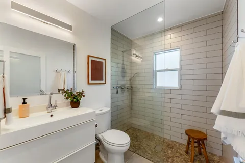 a bathroom with a sink a toilet and mirror