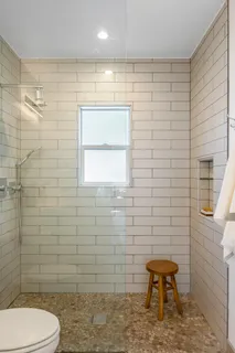 a bathroom with a toilet a sink a shower and mirror
