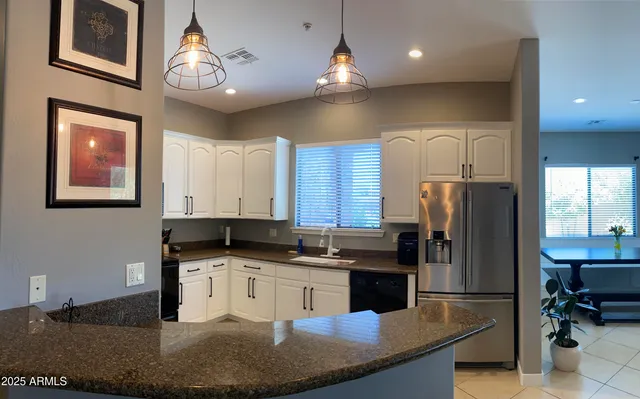 a kitchen with stainless steel appliances granite countertop a sink a stove and a refrigerator