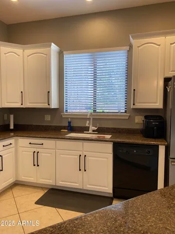 a kitchen with granite countertop a sink and a stove