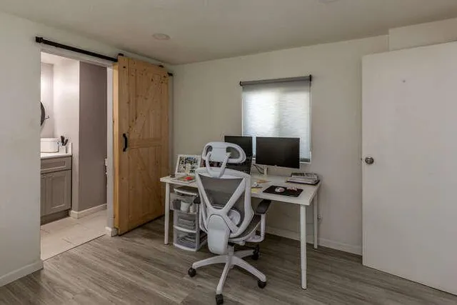 a view of a workspace with furniture and wooden floor