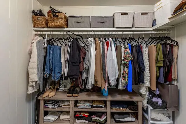 a view of walk in closet with clothes