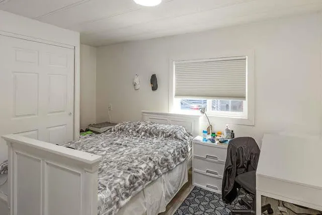 a bedroom with a bed and a window