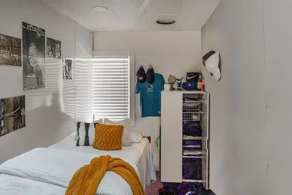 a bedroom with a bed and a potted plant