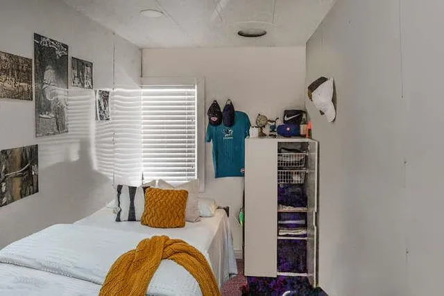 a bedroom with a bed and a potted plant