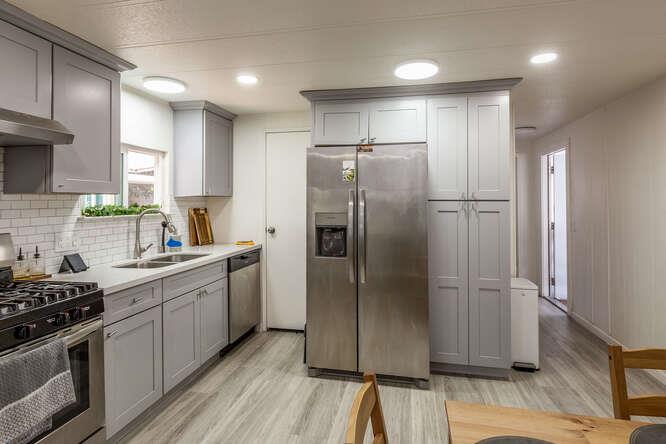 2151 Oakland Road, Unit 297 San Jose, CA 95131 - Photo 4 of 34 a kitchen with stainless steel appliances granite countertop a refrigerator a sink a stove and white cabinets with wooden floor