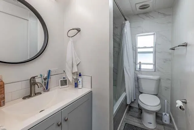 a bathroom with a toilet sink vanity and mirror