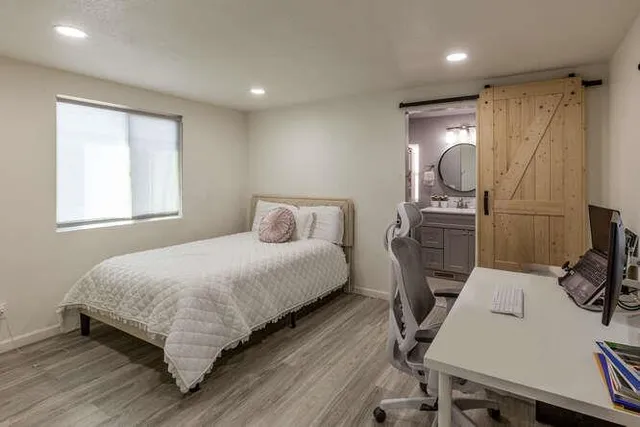 a bedroom with a bed a desk and chair