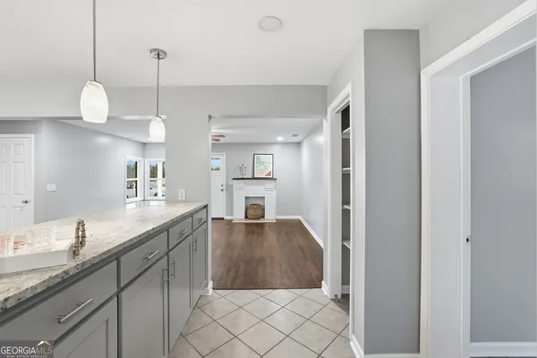 a kitchen with stainless steel appliances granite countertop a refrigerator a sink dishwasher a oven and a dining table with wooden floor