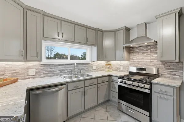 a kitchen with stainless steel appliances granite countertop a sink stove and cabinets