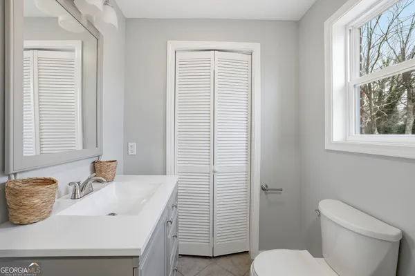 a bathroom with a toilet a sink and a window