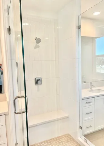 a bathroom with a granite countertop sink a mirror and shower