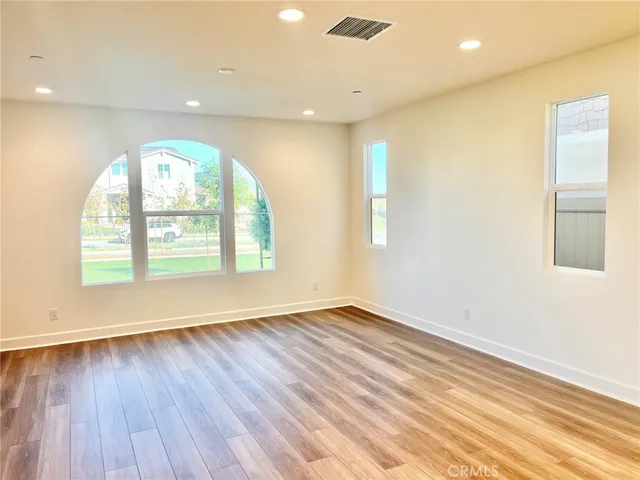 an empty room with wooden floor and a window