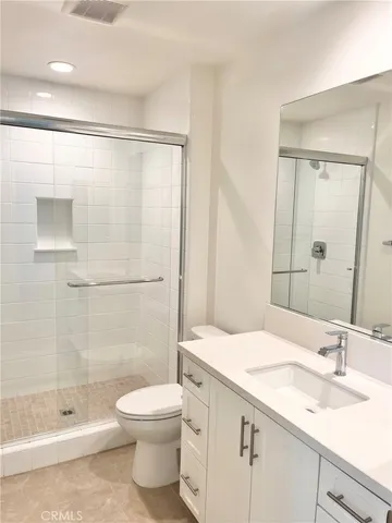 a bathroom with a granite countertop sink toilet and shower