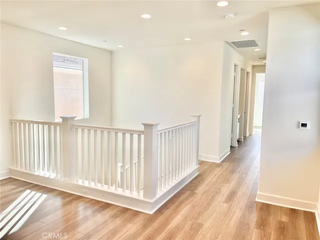 a view of a hallway with wooden floor and windows