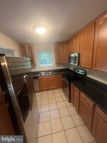 a kitchen with a sink a stove top oven and cabinets