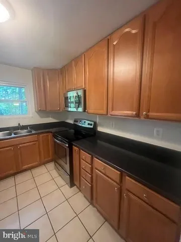 a kitchen with granite countertop stainless steel appliances a sink a stove top oven and granite counter tops