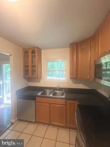 a kitchen with granite countertop a sink window and cabinets