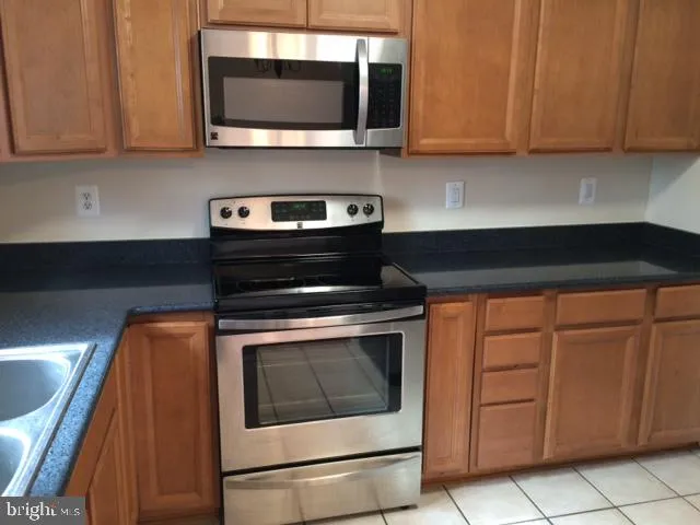a kitchen with stainless steel appliances granite countertop a stove microwave and sink