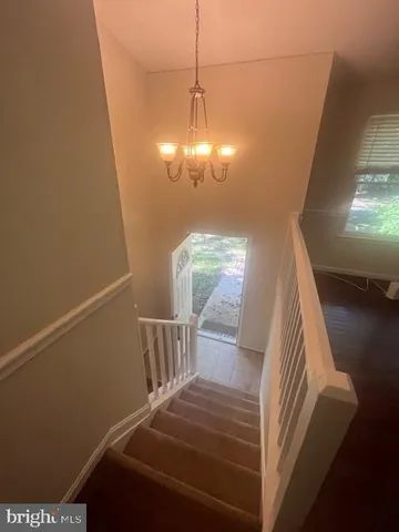 a view of a livingroom with wooden floor and stairs