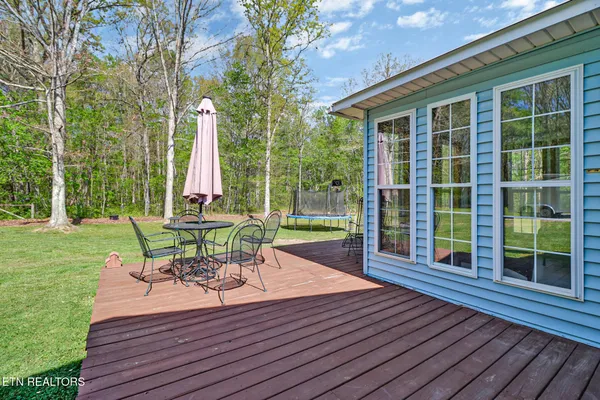 a patio with wooden floor and outdoor seating