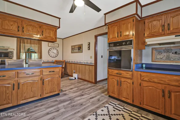 a kitchen with a refrigerator a sink dishwasher a dining table and chairs with wooden floor